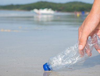 Ramasser une bouteille d’eau sur la plage.