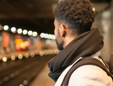 Un jeune homme de profil attend le RER un quai