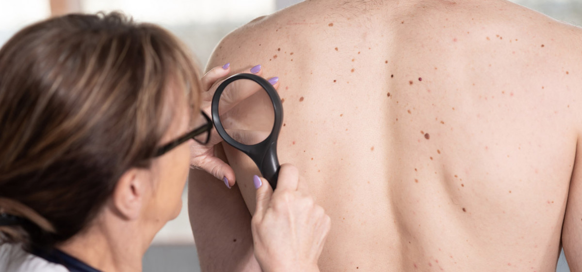 Une dermatologue examine la peau d’une jeune fille.